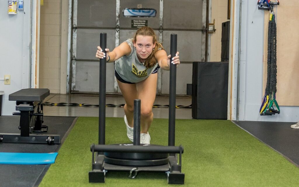 An athlete pushing a sled in the WHS training center