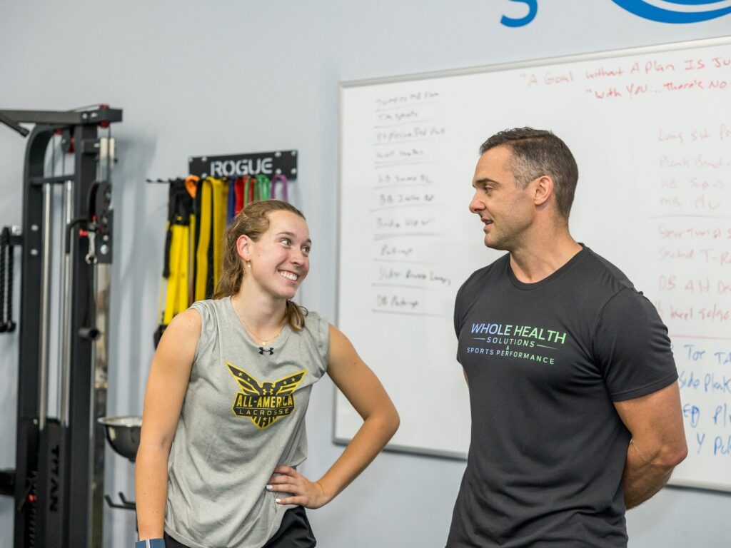 Athletic performance coach and athlete talking through a training plan