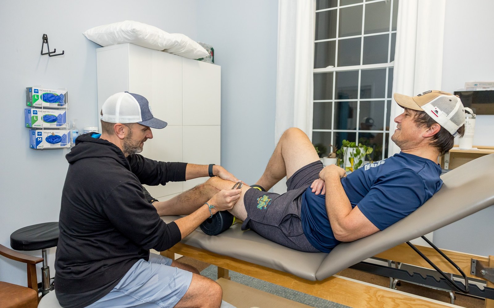 Physical therapist working on a client's knee on the treatment table