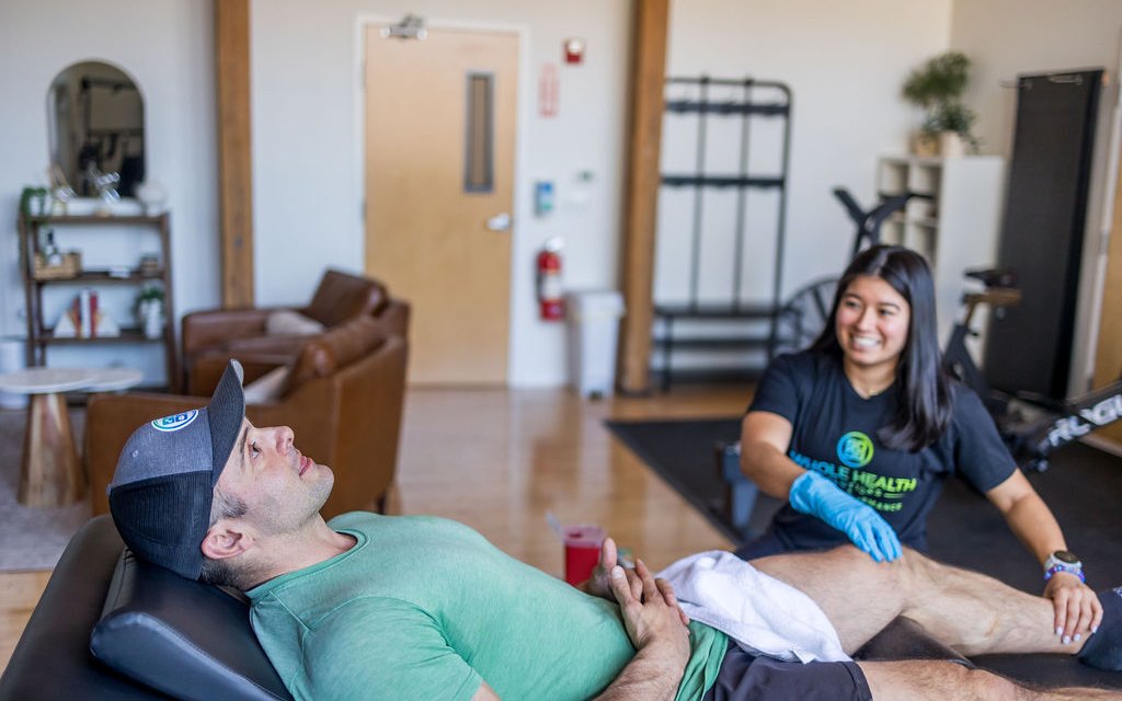 Physical therapist smiling with a client during a session at Whole Health Solutions