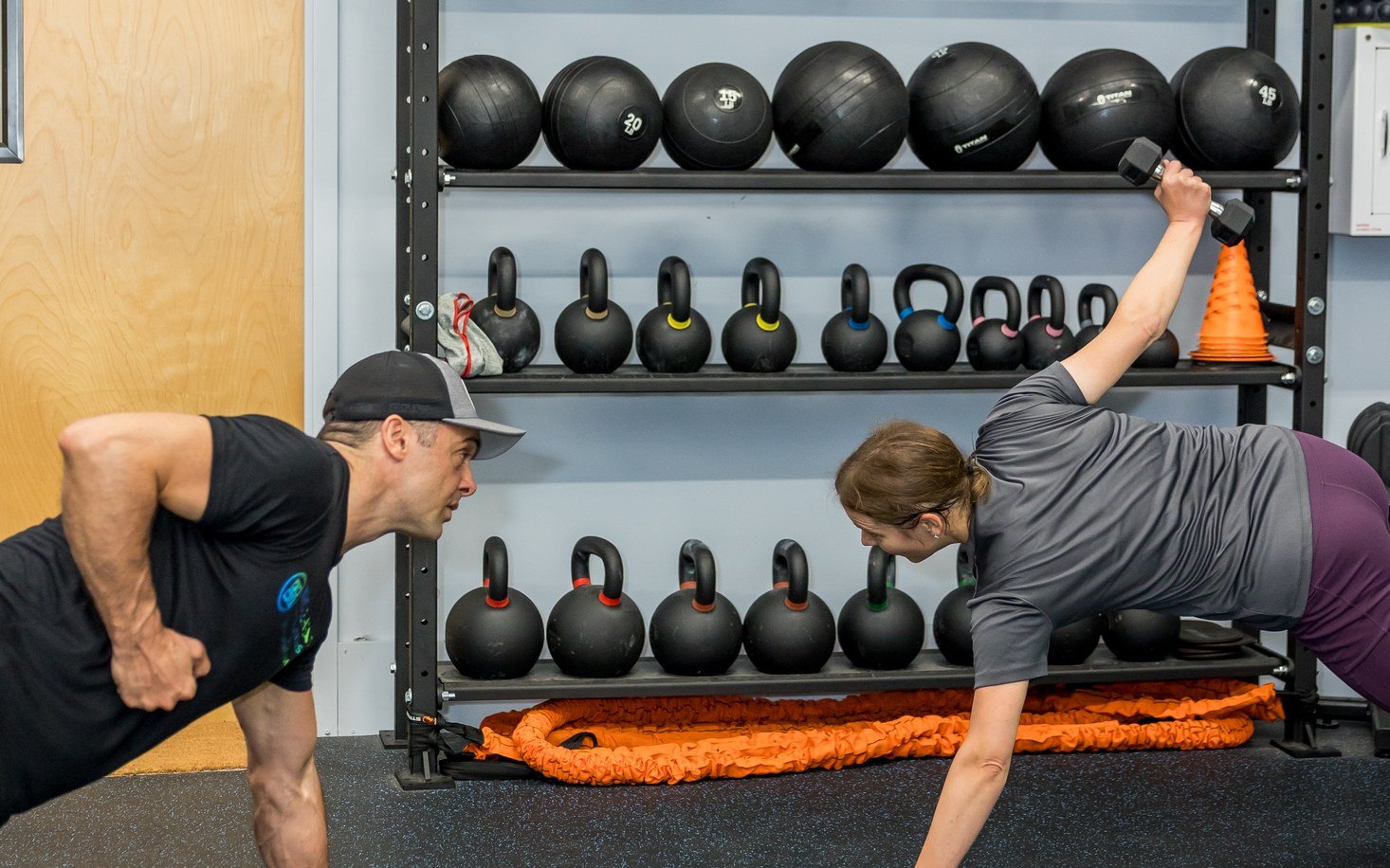 Coach and client doing a single arm dumbbell row together
