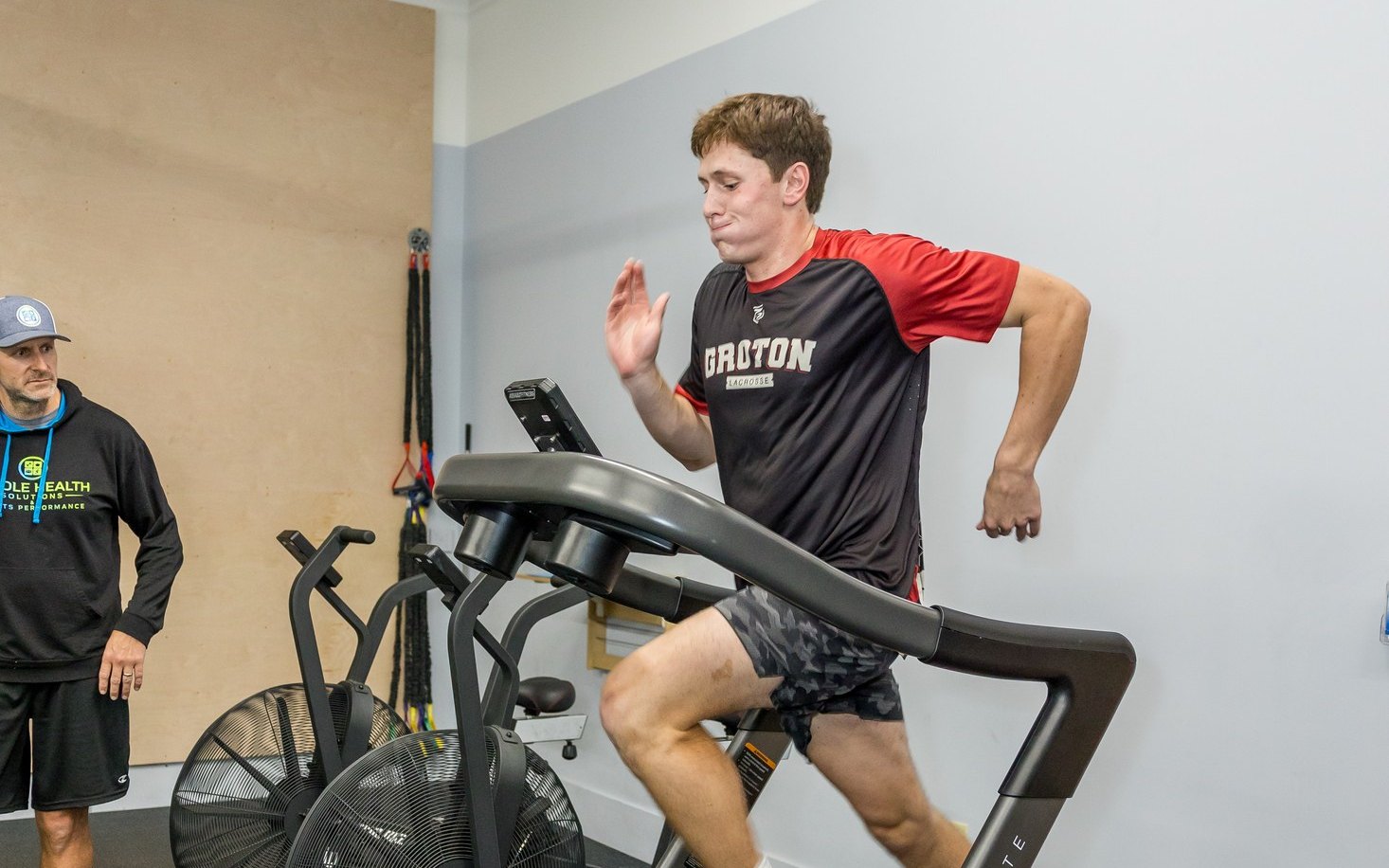 Young runner sprinting on a curved treadmill in the WHS training center