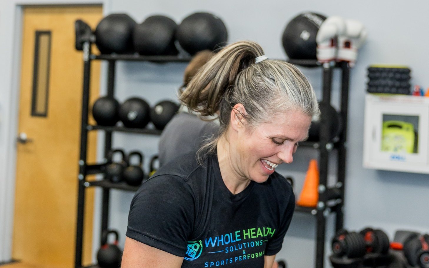 Smiling client training with a kettlebell at Whole Health Solutions