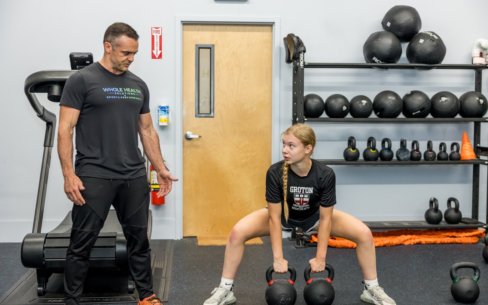 Performance coach watching an athlete set up a kettlebell deadlift