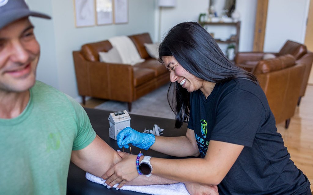 A physical therapist treating a client's forearm and wrist