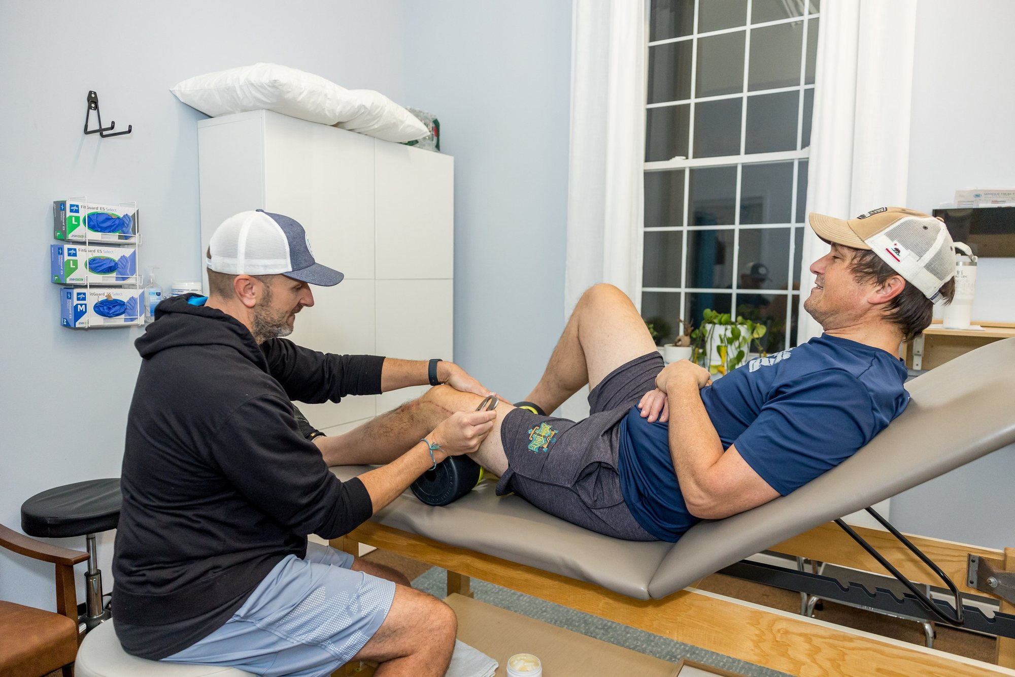 Physical therapist treating a client's knee at Whole Health Solutions in Shirley, MA