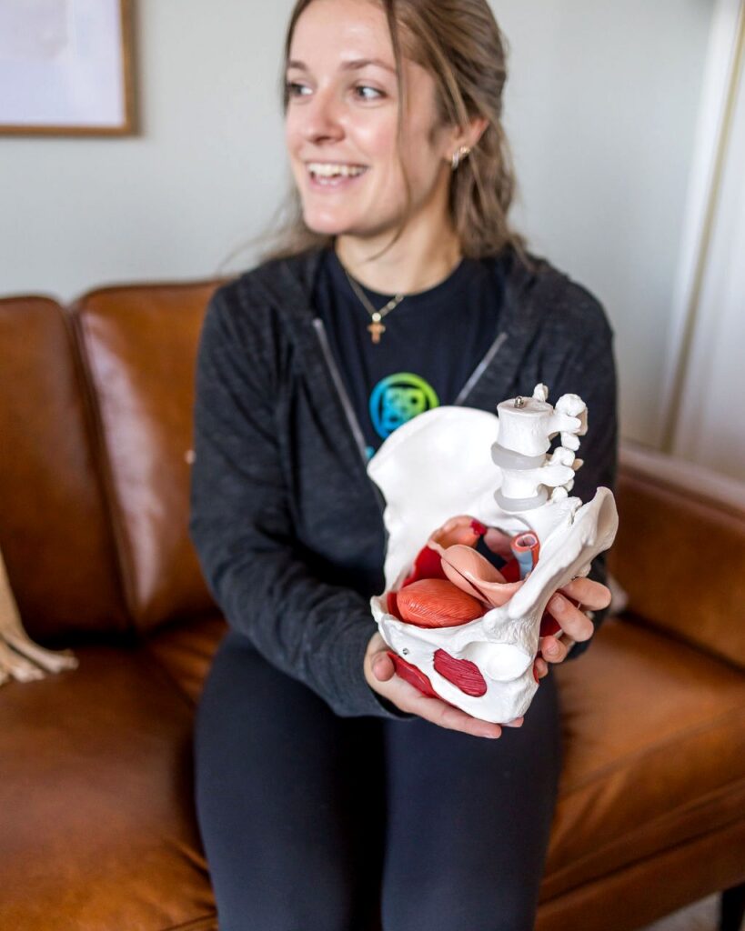 Pelvic floor physical therapist smiling with a pelvis model in the Pelvic Health Center