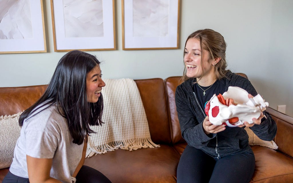 A pelvic health physical therapist and client laughing during a consultation