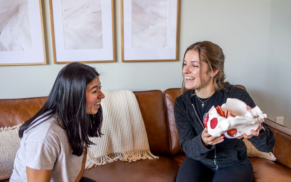 Pelvic health physical therapist and client laughing during a consultation