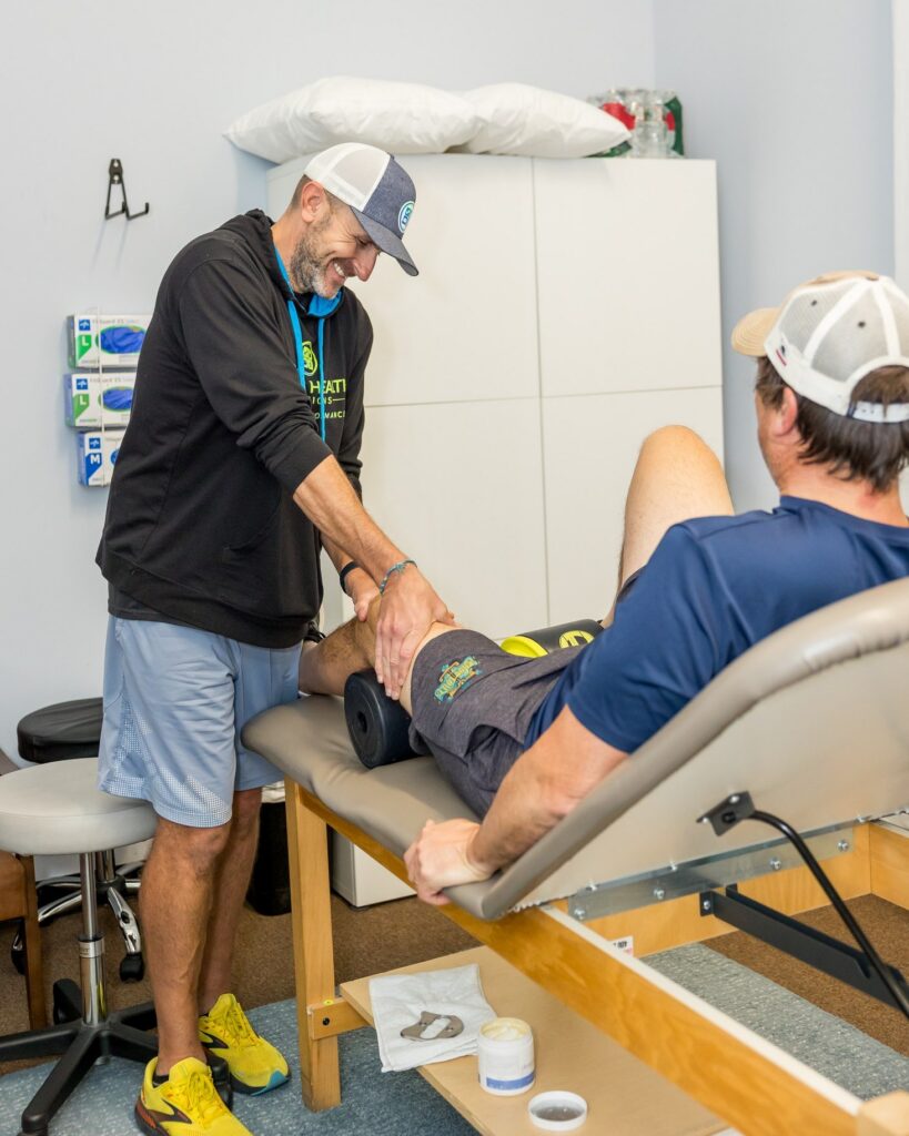 A physical therapist treating a client's knee at Whole Health Solutions