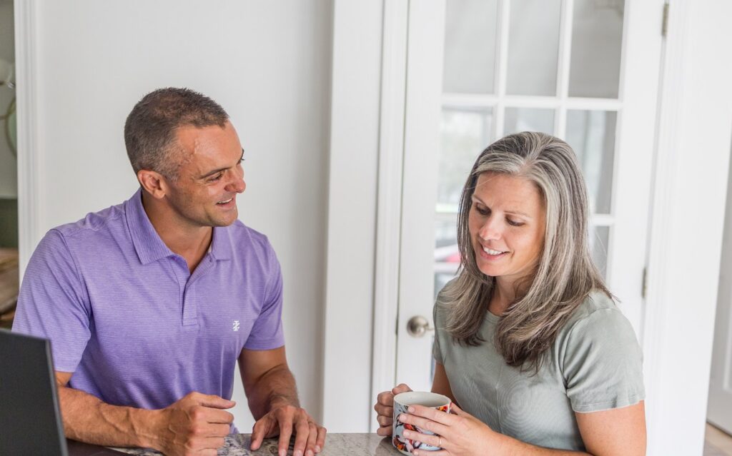 Health coach and client talking through sleep and stress habits over coffee