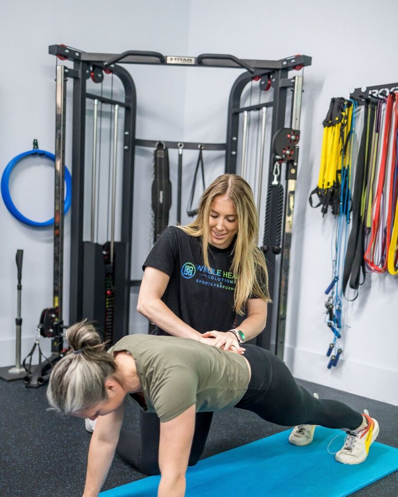 Julia Hill, DPT, guiding a client through a balance and core exercise at Whole Health Solutions in Shirley, MA