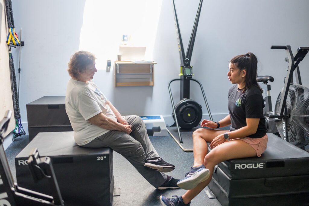 Physical therapist talking with a client about her symptoms in the WHS clinic